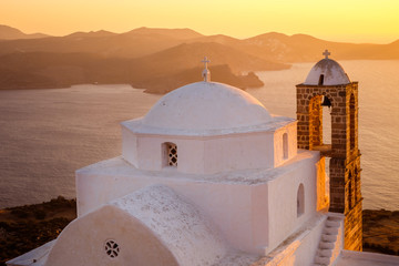Scenic view of traditional Greek church with ocean background at sunset