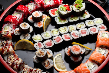 Japanese cuisine. Asian food. Sushi set on a wooden round plate. Stone background.