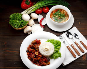Business lunch. Soup and the second dish. Wooden table.