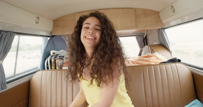 Portrait African American Teenage girl posing for camera holding up ripe pineapple fruit smiling at festival in camper van on road trip adventure
