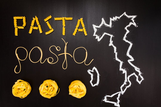 Words pasta made of cooked spaghetti and dry pasta on the black background with frame of country Italy written by chalk