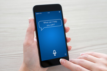 Women hands holding phone with app personal assistant on screen