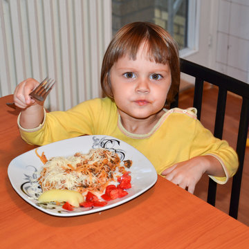 Cute little brown hair girl eating spaghetti 