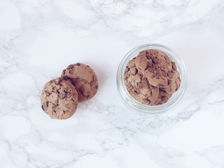 Crisp chocolate cookies on marble background. Flat lay. Top view
