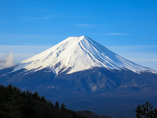 Naklejka na ściany i meble Fuji mountain top filled with white snow and blue sky background