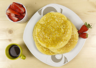 Pancakes and strawberries on wood background - top view