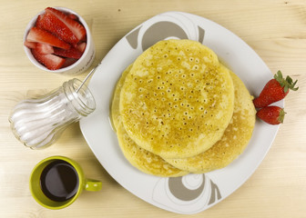 Pancakes and strawberries on wood background - top view