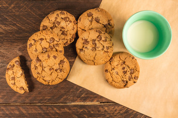 Chocolate chips cookies on baking paper, with milk