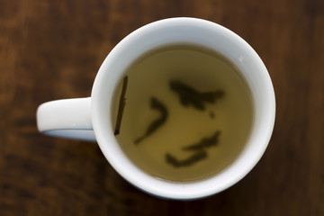 Hot tea in a white cup on a wooden table
