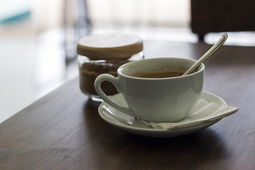 Fresh coffee in white cup on wooden table