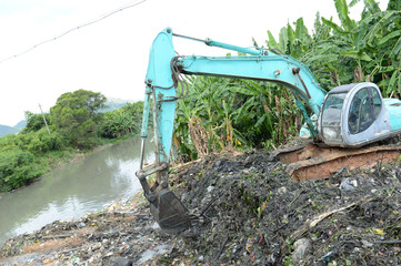 Excavator service in the polluted river.