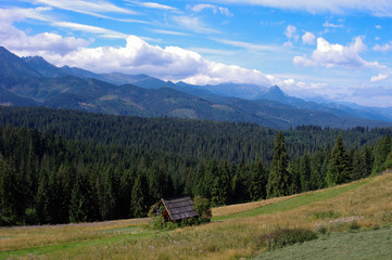Widok na mały domek i Tatry 