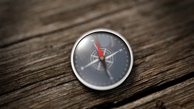 Gros plan sur une boussole dont l'aguille s'oriente vers le Nord sur une table en bois. Concept d'objectif. Rendu 3D

