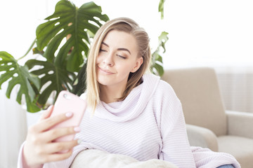 Picture of happy woman with smartphone on sofa