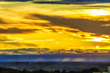 gloomy stormy sky with a glimpse of the sun and bright sun rays above the earth. Nature, landscape.
