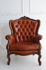 Vintage leather Luxury brown armchair Classic Brown leather sofa and on a wooden floor white stucco on a white background