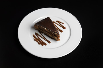 Chocolate cake on a white plate in a cafe