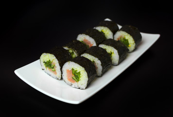 Sushi of norimaki with trout and cucumber on slate plate