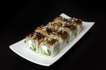 Sushi with eel on white plate on a black background