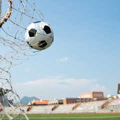 soccer ball in goal. isolated on blue sky background.