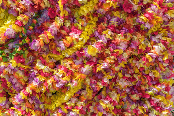 Fototapeta na wymiar Hintergrund aus bunten Blumengirlanden überwiegend in roten und gelben Farbtönen