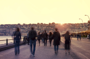 Embankment with groups of people in the evening in Napoli, Italy