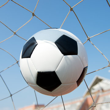 soccer ball in goal. isolated on blue sky background. © xy