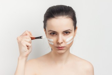Fototapeta premium skin care, white lines on the face of a woman