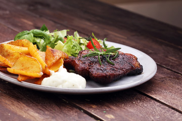 Grilled steaks, baked potatoes and salad
