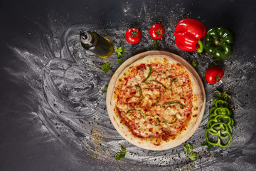 whole italian pizza on wood table with ingredients in black table
