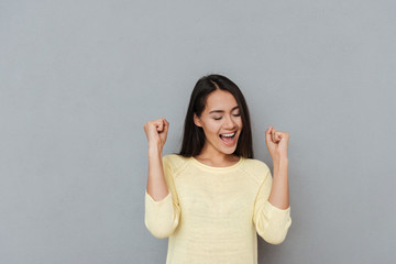 Happy successful young woman shouting and celebrating success
