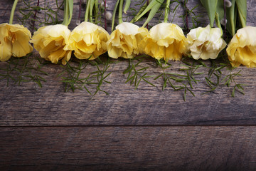 Spring background with light yellow tulips on old wooden desk. Easter,  Mother's, Valentines, Women's Day..Top view with copy space. Place for text.