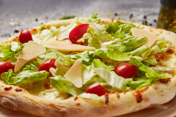 whole italian pizza on wood table with ingredients in black table