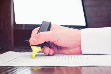 Businessman in marking document with marker