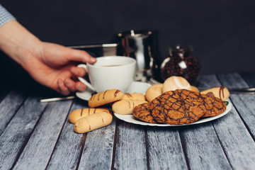 oatmeal and shortbread cookies, a cup with a drink in hand
