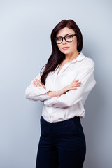 Successful confident young woman with spectacles crossing hands