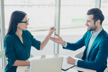 Broker and buyer having a meeting in a restaurant. Smiling woman in glasses giving keys to happy handsome man