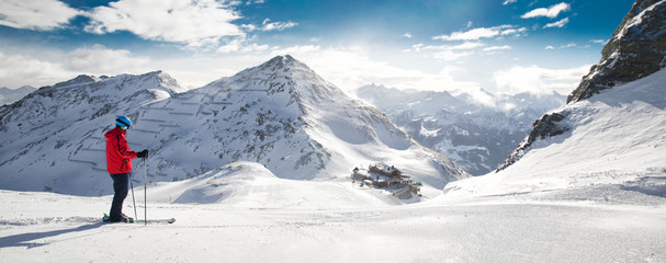 Man skiing on the prepared slope with fresh new powder snow in Tyrolian Alps, Zillertal, Austria - obrazy, fototapety, plakaty