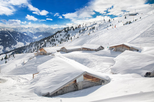 Trees covered by fresh snow in Tyrolian Alps skiing resort with wooden cottages, Zillertal, Austria