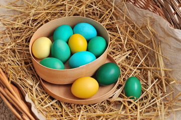 Naklejka na ściany i meble Wooden basket full of colorful eggs