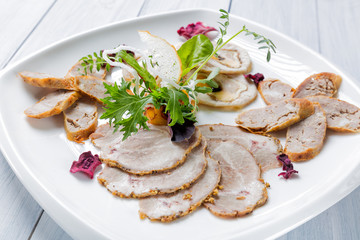 Meat plate with delicious pieces of sliced ham, sausage, herbs and meat with herbs. Close up with selective focus