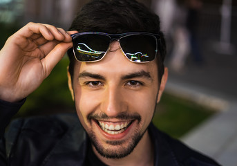 Smiling man in sunglasses with colorful reflection
