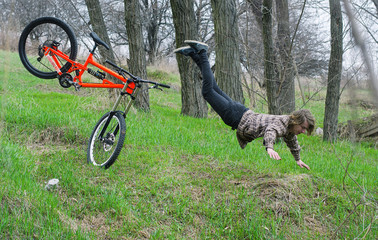 A young male extreme falls from a bicycle.