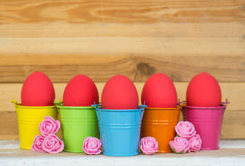 red Easter eggs with Rabbit ears in colored buckets, selective focus image, Card Happy Easter 