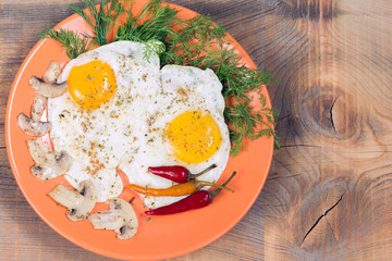 Fried eggs with champignons, dill and red chili pepper