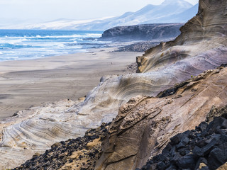 Colorful sediment and volcanic structures in the south west of the Canary Island Fuerteventura at the beach.