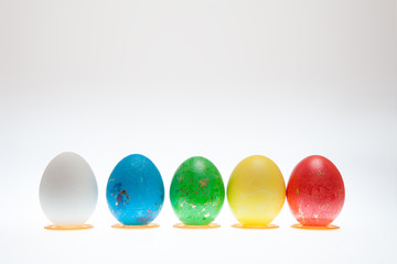 Five Easter eggs on pedestals on a white background