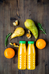 plastic bottles with fruit drinks on wooden background top view mockup
