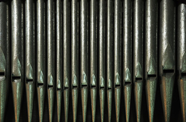 A row of silver metal organ pipes from Guilsborough Church, Northamptonshire, England