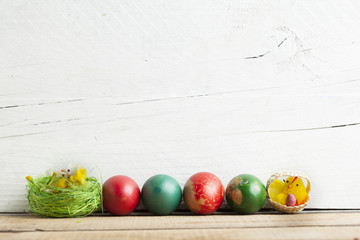 Easter eggs and white wooden country table, background and texture, copyspace